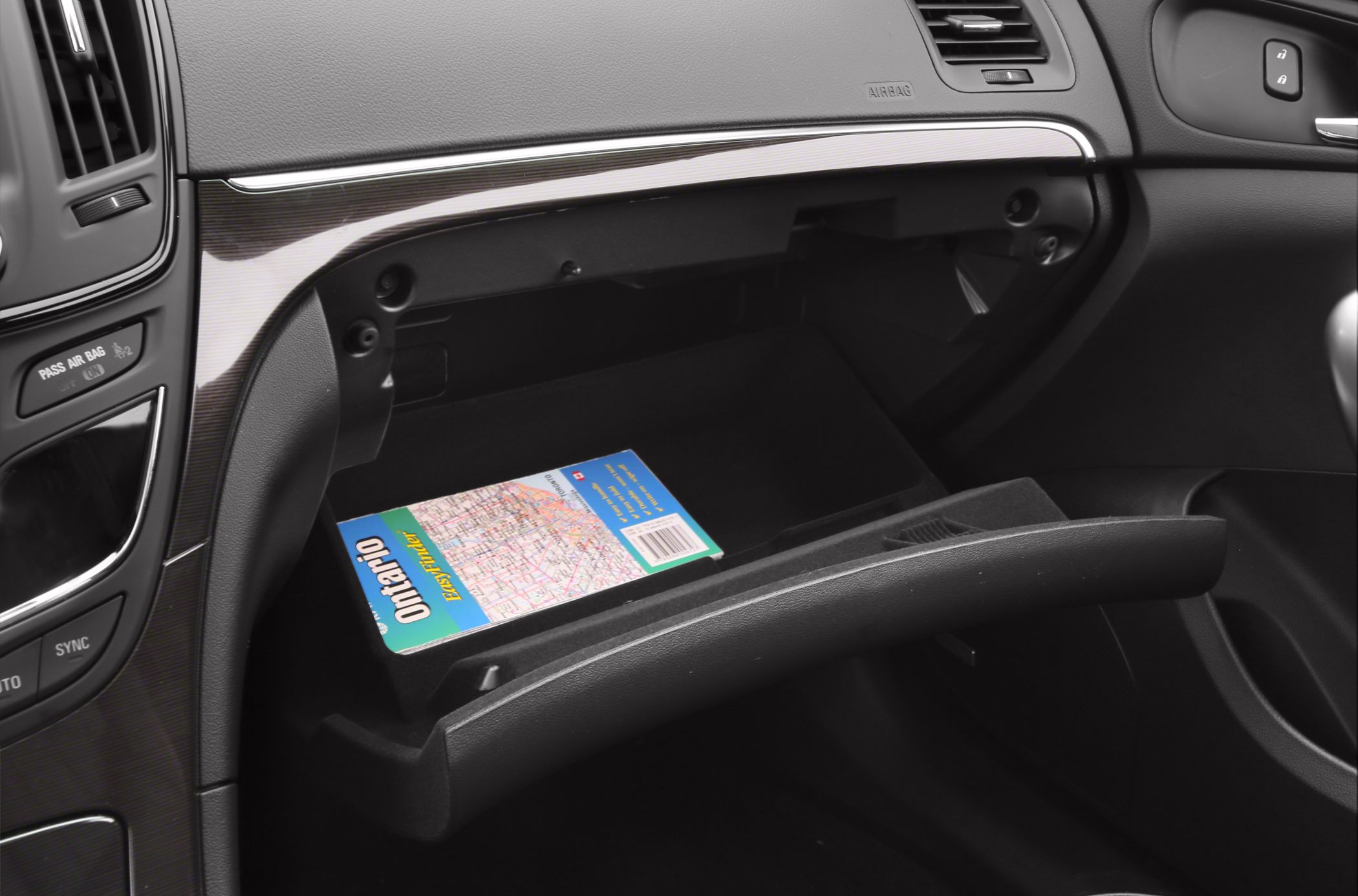 Open glove box with map inside in car interior