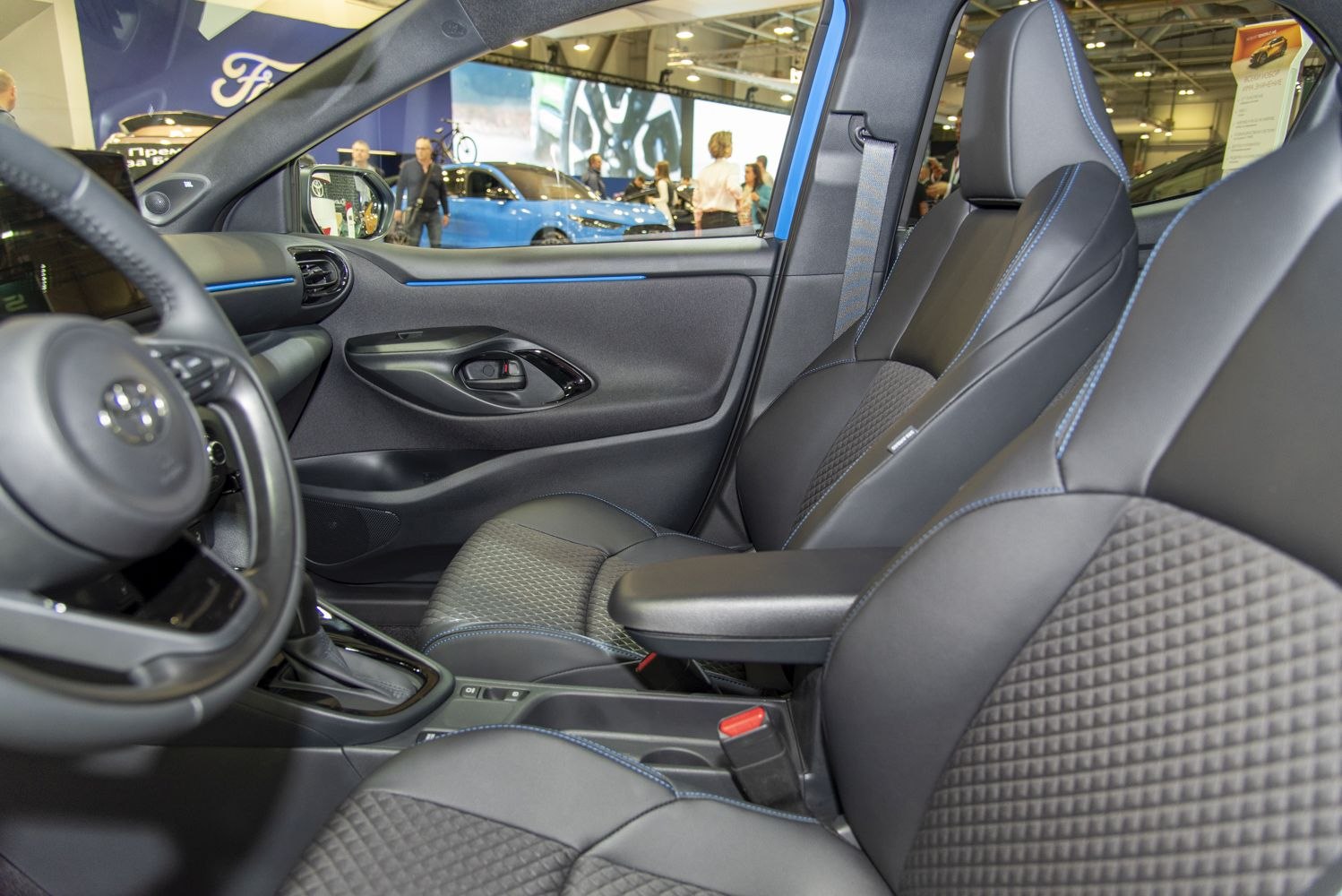 Sporty leather-trimmed seats with blue stitching and modern dashboard elements