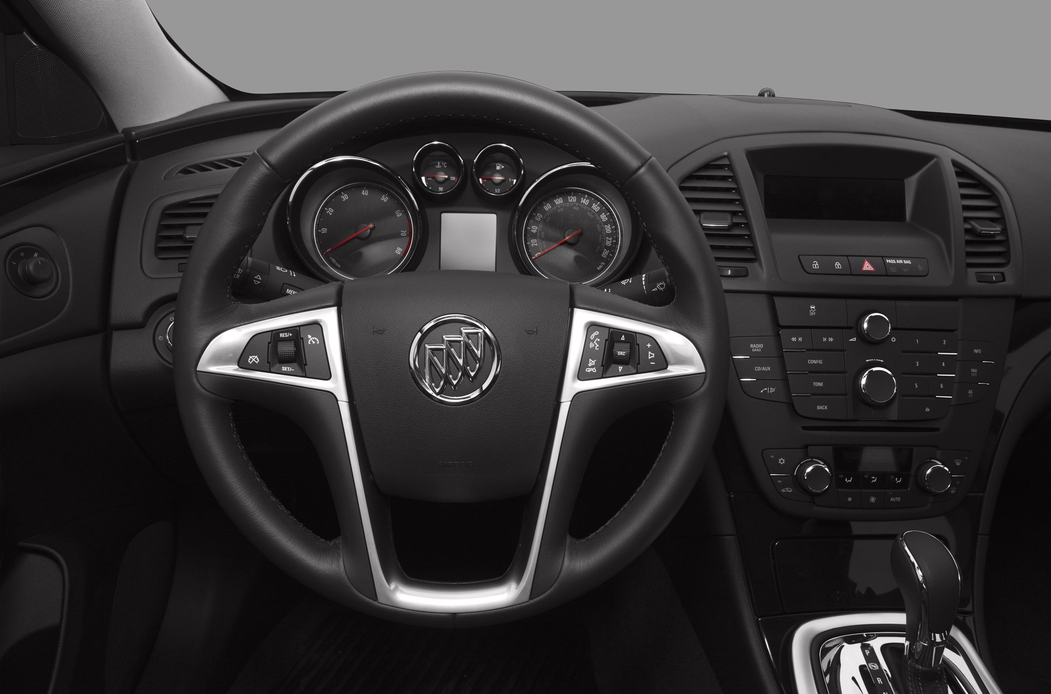 Steering wheel with controls, instrument cluster, center console with gear lever