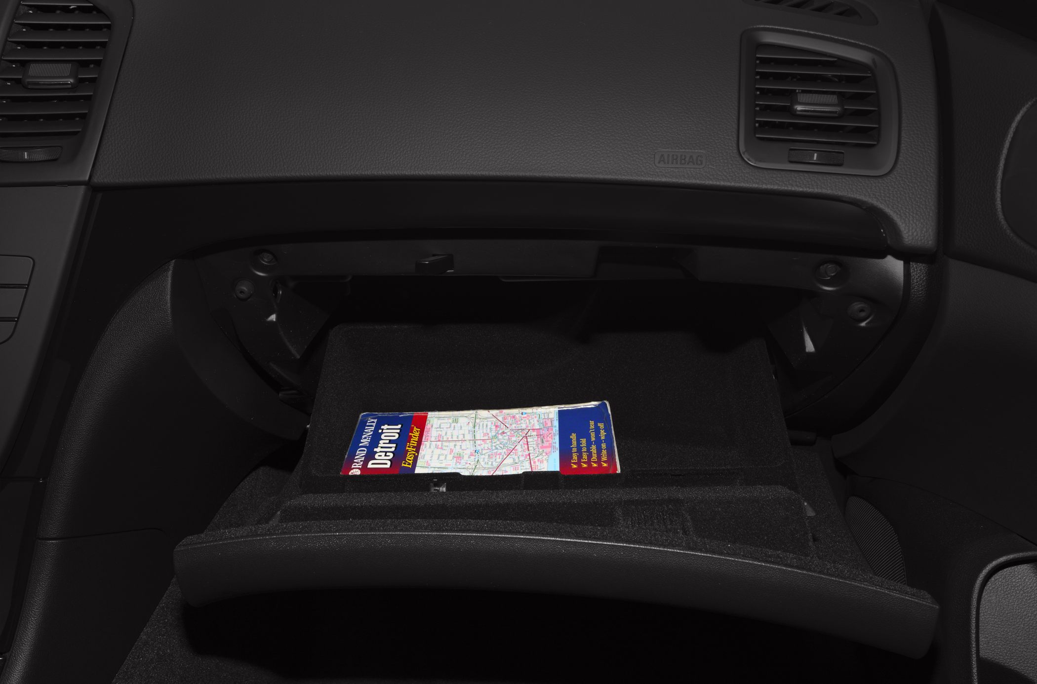 Open glove box interior storage with a map inside