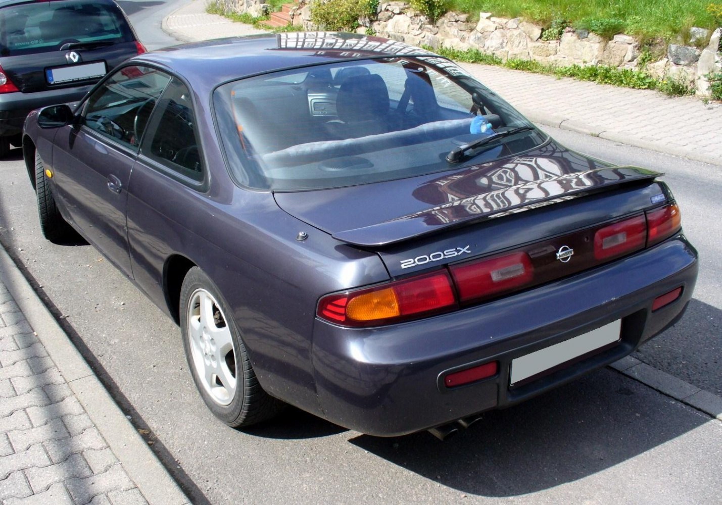 Rear view of a coupe with distinct tail lights and spoiler