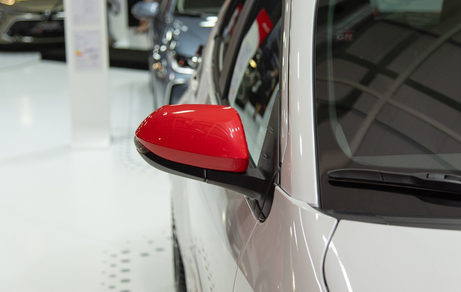 Red side mirror on a modern white vehicle