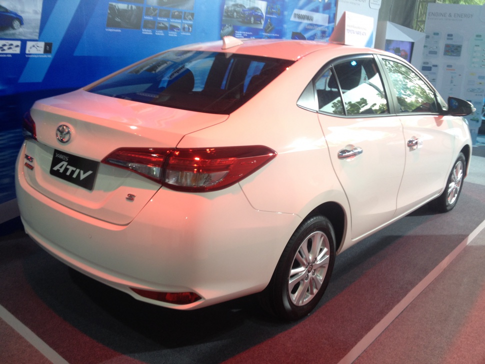 Rear and side profile of a white compact sedan with chrome accents