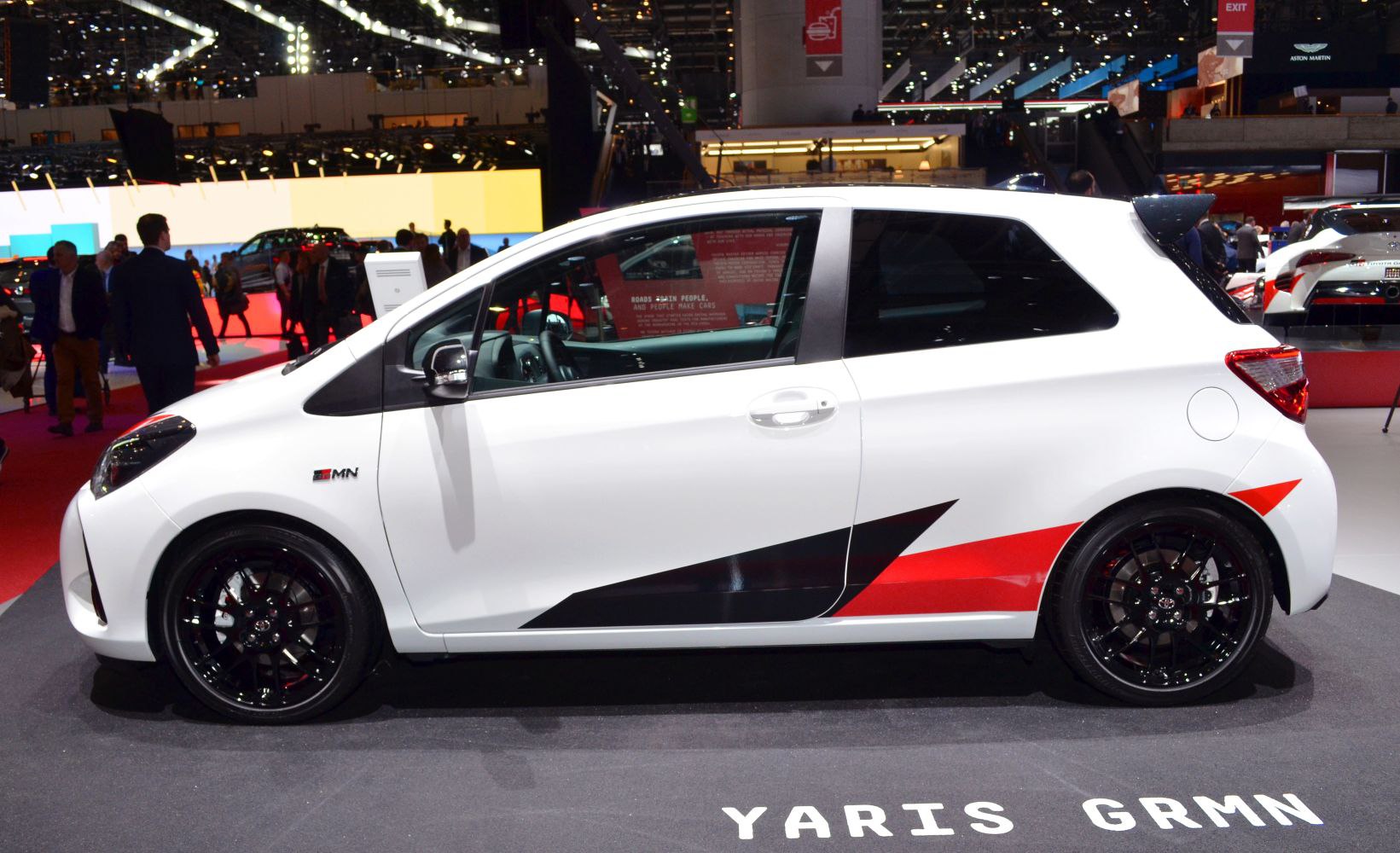 Side view of white hatchback with sporty black and red decals and black alloy wheels