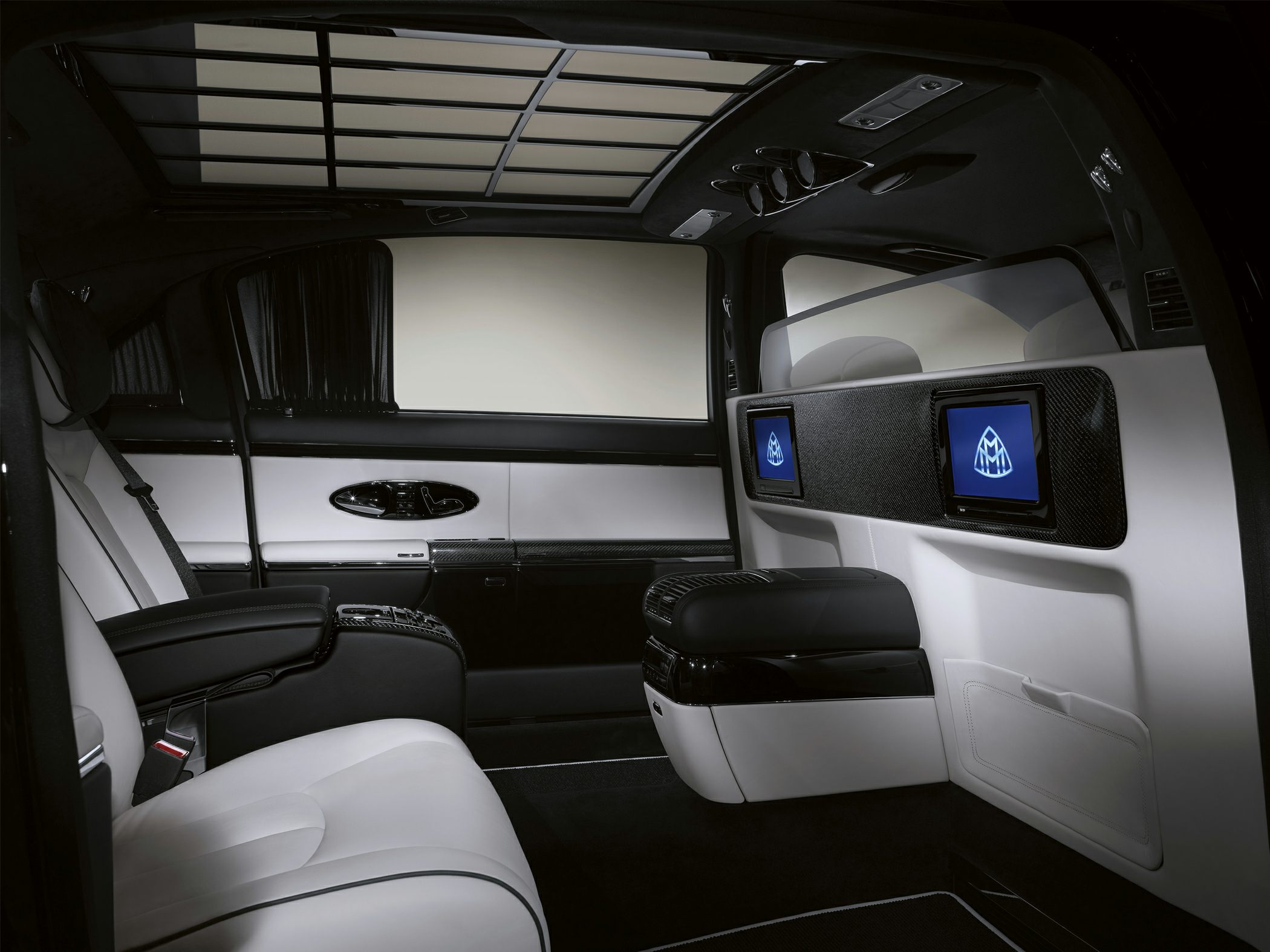 Luxurious interior with dual monitors, glass partition, and premium leather seats