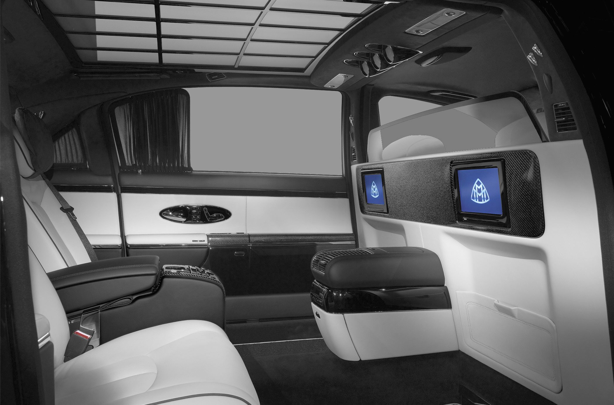 Reclining rear seats with dual screens and carbon fiber accents in luxury interior