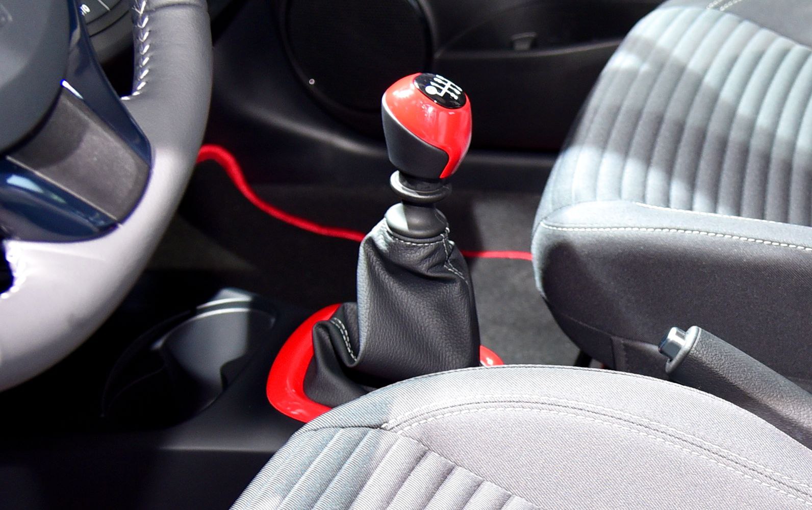 Manual gear shift lever with red accent and fabric car seats