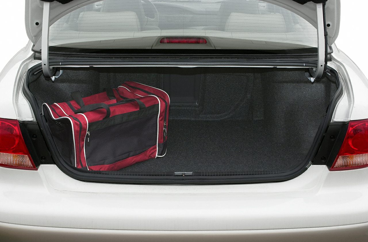 Open car trunk with red travel bag inside