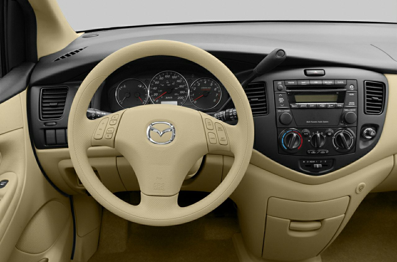 Beige steering wheel and dashboard with instrument cluster and audio controls