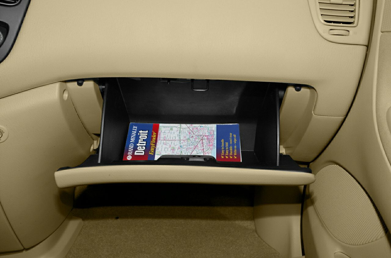 Open glove compartment with map inside in beige car interior