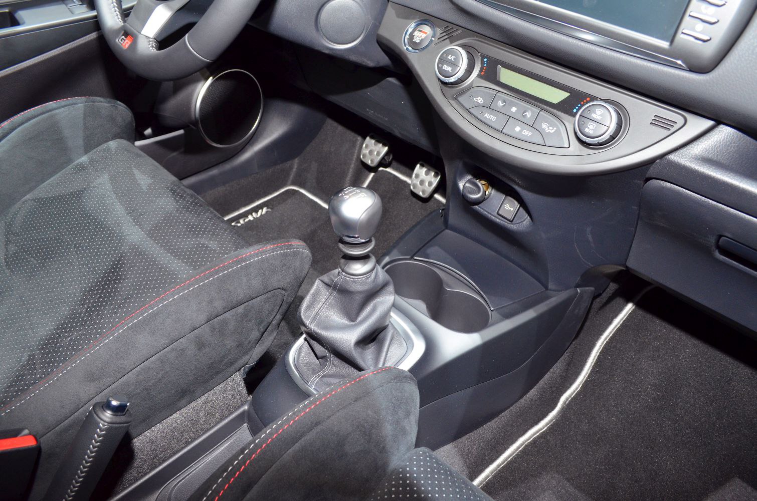 Manual gear shift and sporty black seats with red stitching
