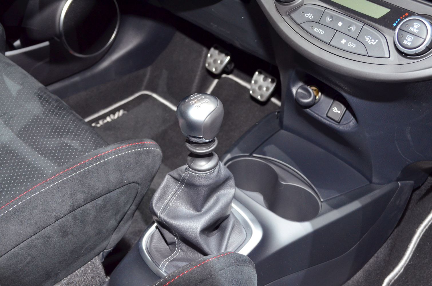 Manual gear shift lever and metal foot pedals inside car