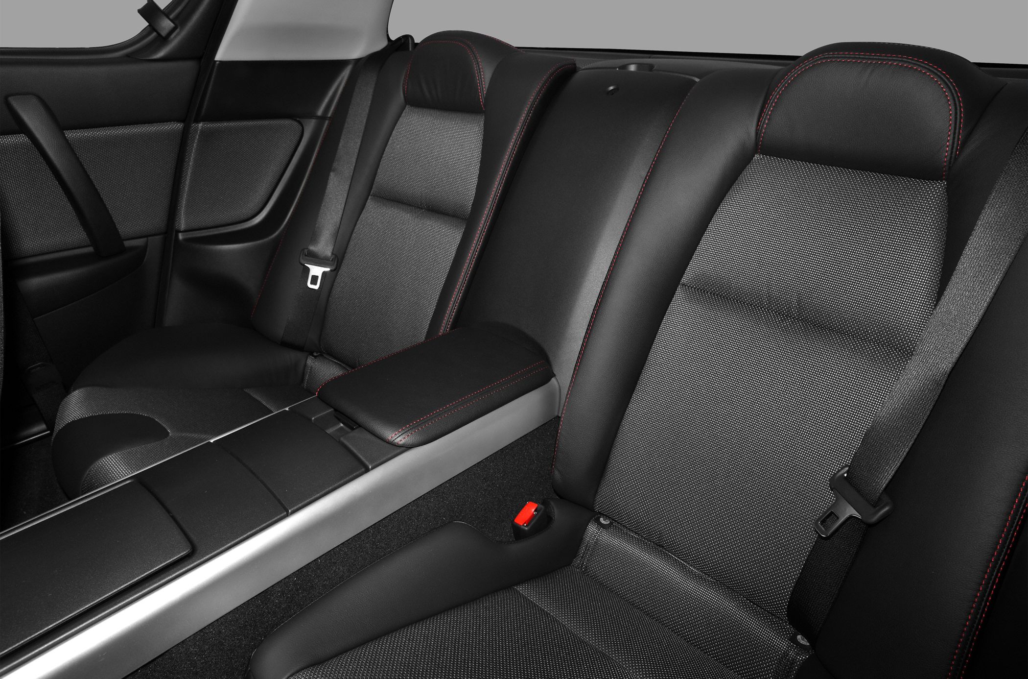 Rear seat with leather and fabric upholstery with red stitching and seat belts