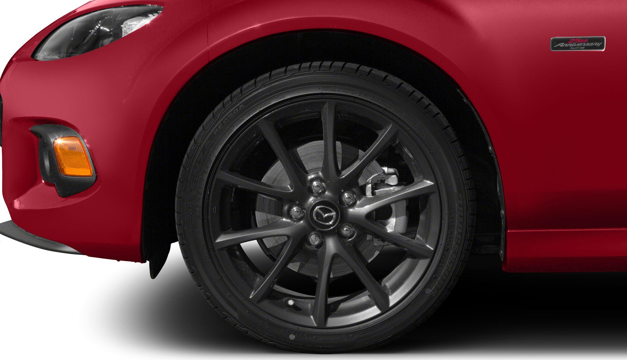 Close-up of alloy wheel and front light on red sports car