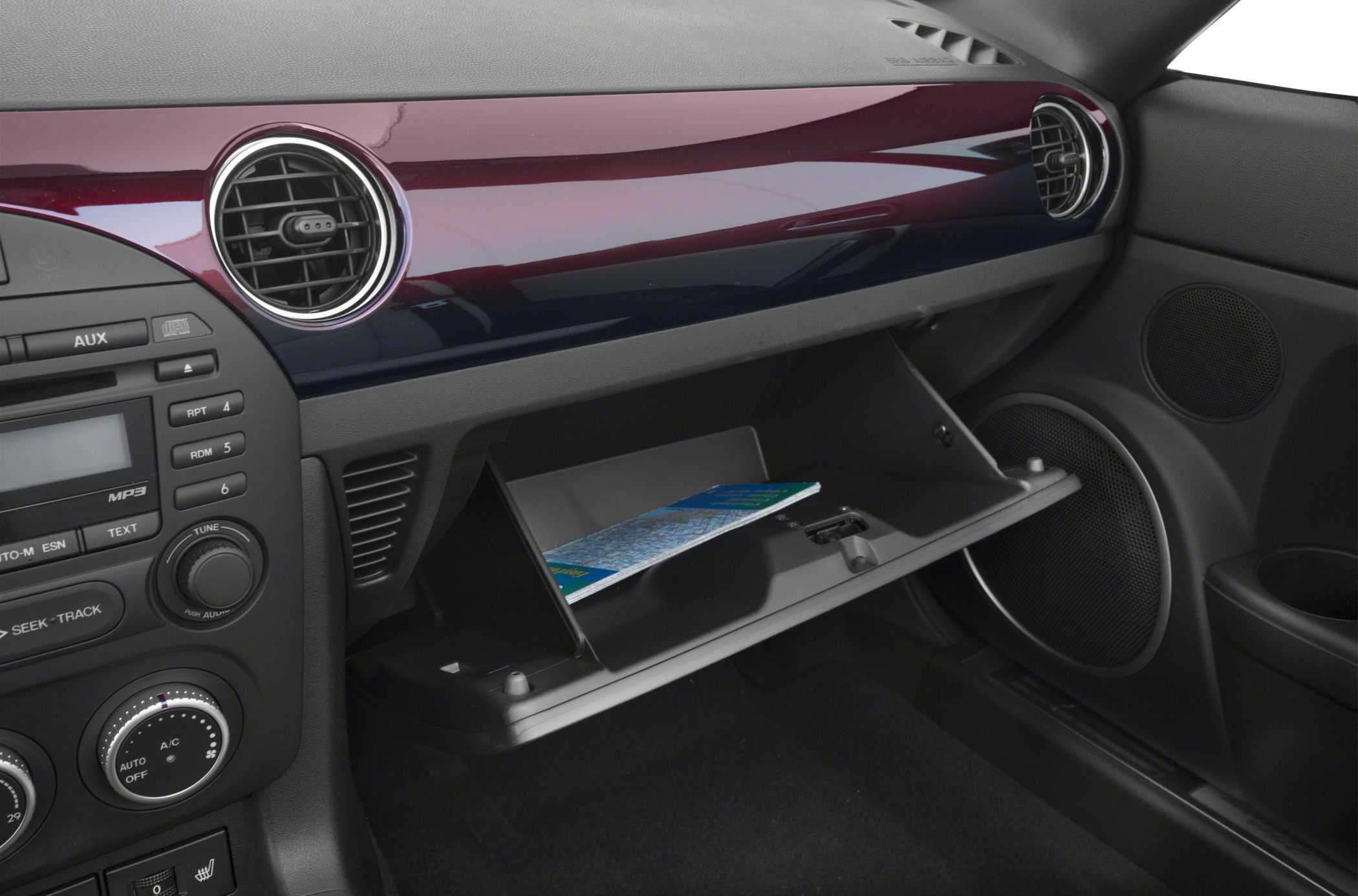 Open glovebox and dashboard with audio controls and circular vents