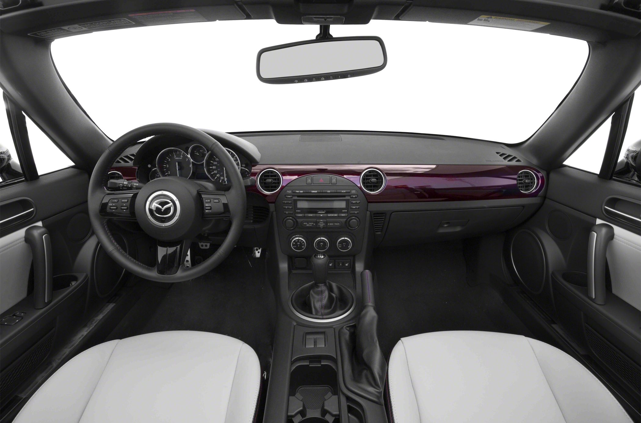 Manual transmission, analog gauges, central console with round air vents.