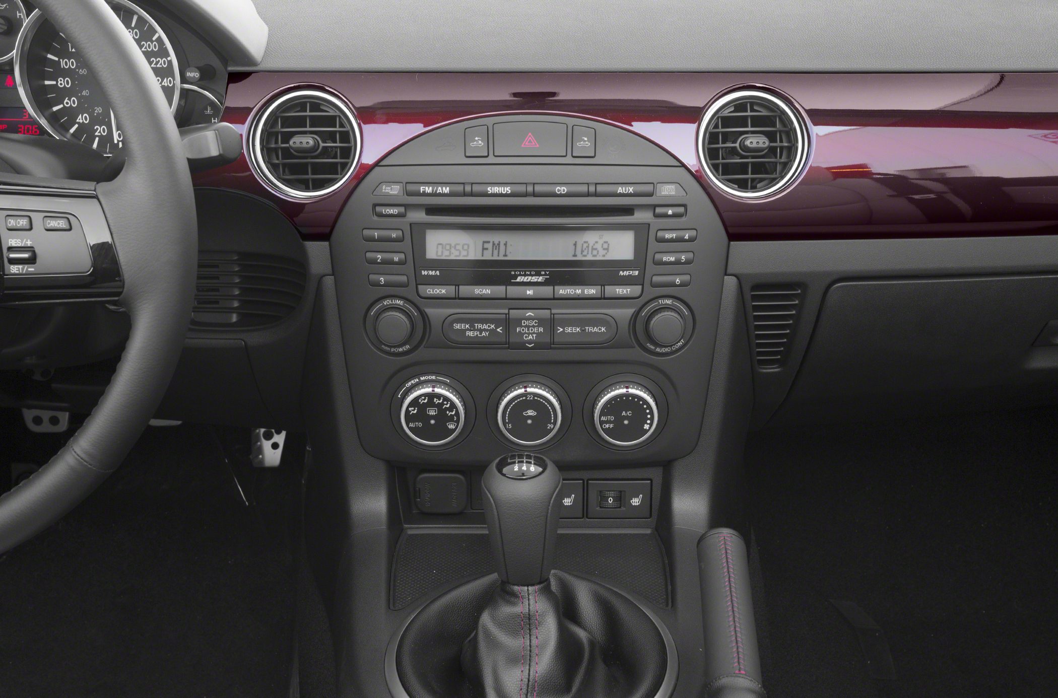 Manual gear shifter, climate controls, audio system on dashboard