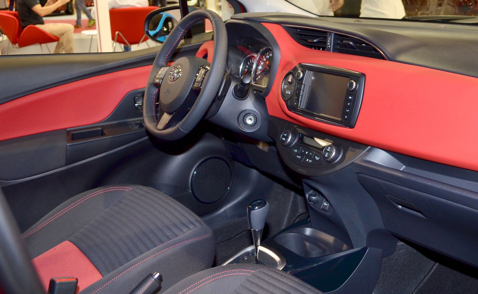 Red dashboard and steering wheel with infotainment system and automatic gearshift