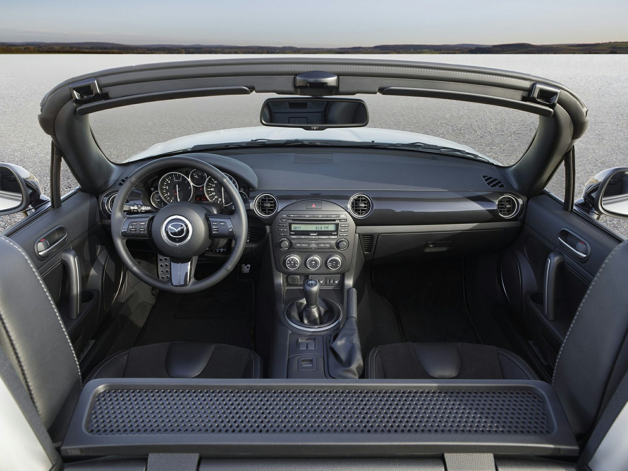 Convertible car interior with manual gearstick and dashboard
