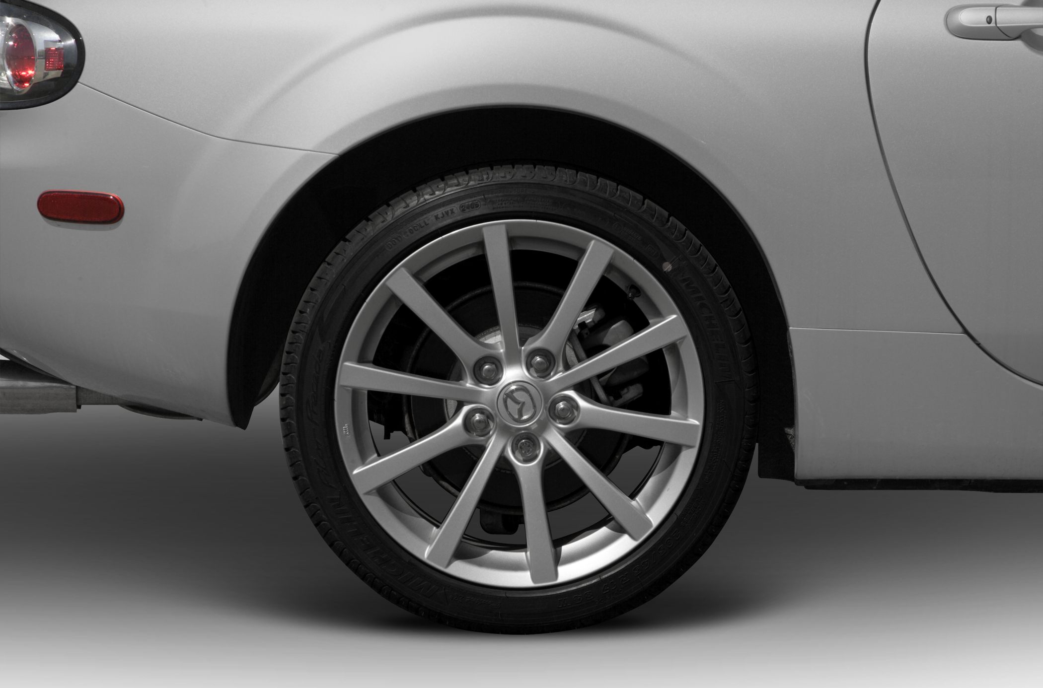 Close-up of a 10-spoke alloy wheel and rear wheel arch with tire