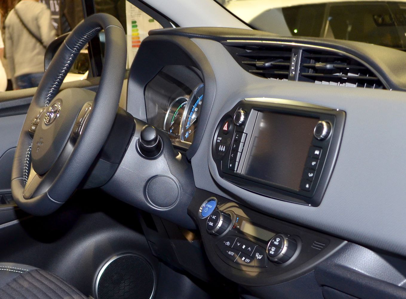 Interior dashboard with steering wheel, infotainment screen, and climate controls