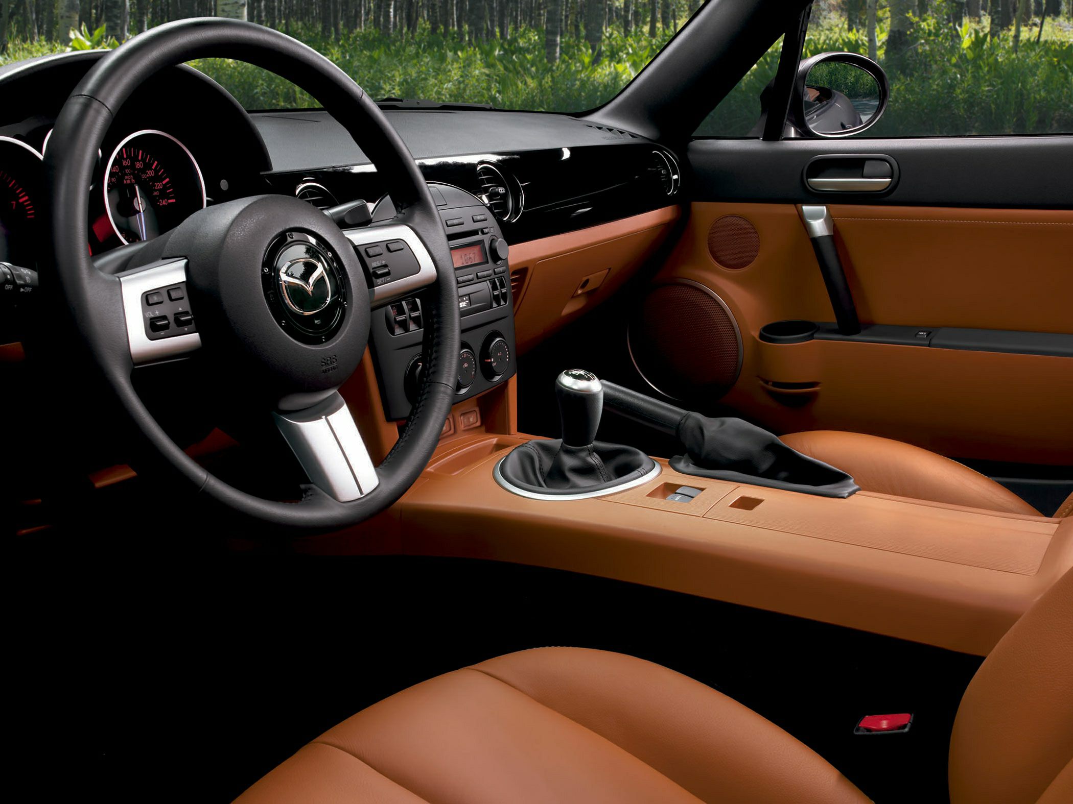 Manual gear shift and tan leather seats in a sporty car interior