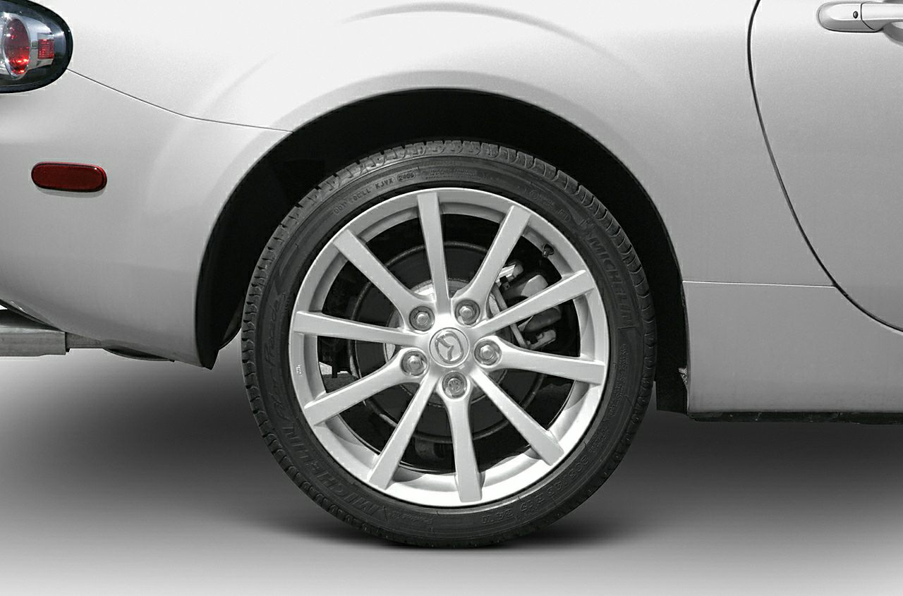 Rear wheel with alloy rim and tire on silver car body