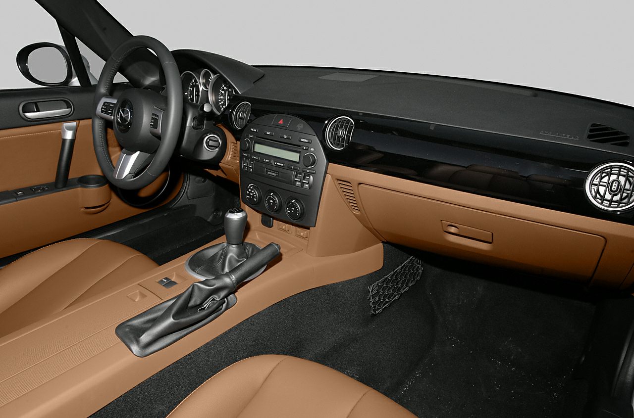 Car interior showing dashboard, steering wheel, and center console with manual gear stick