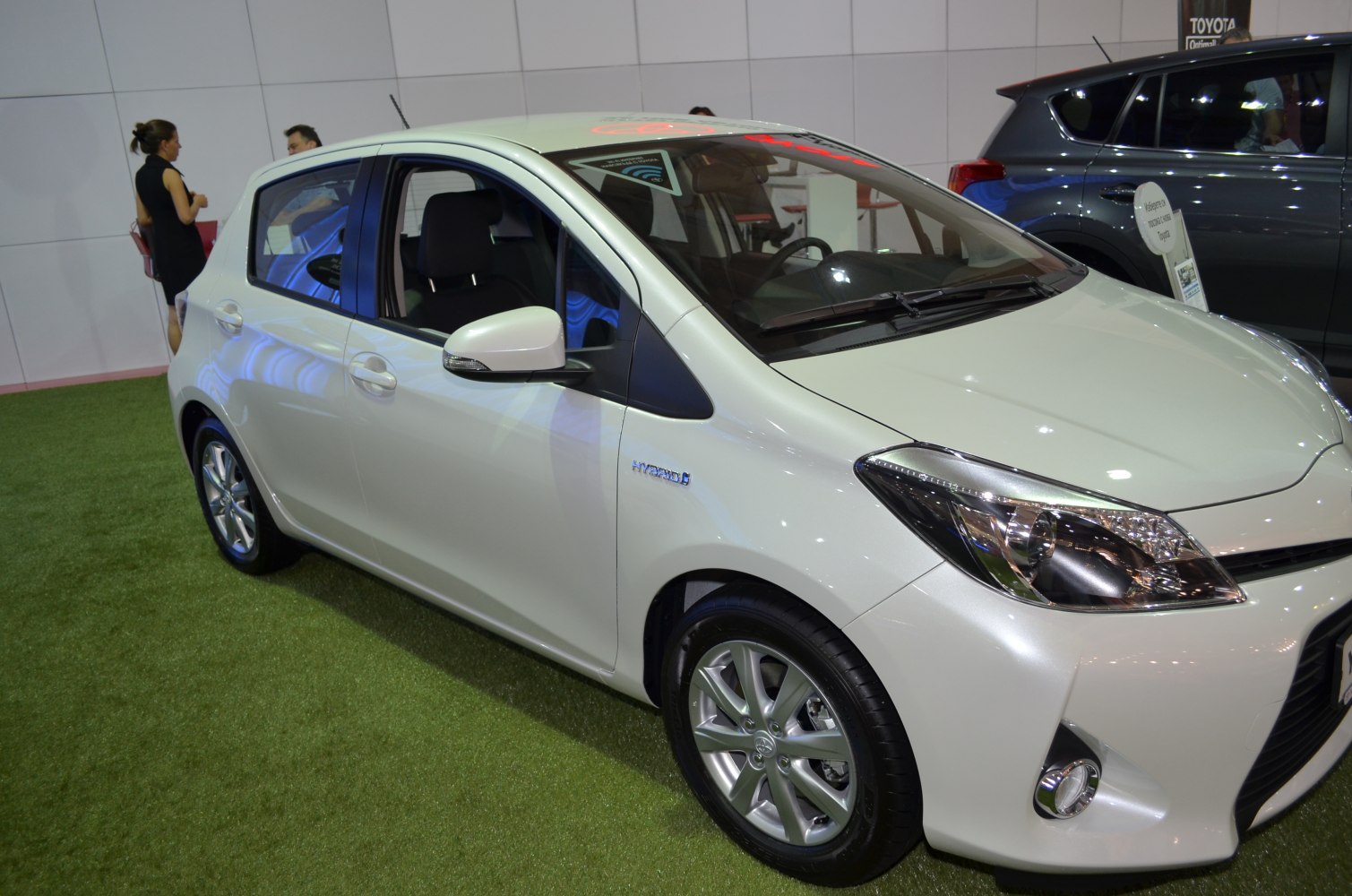 Front side view of a hybrid compact hatchback with alloy wheels.