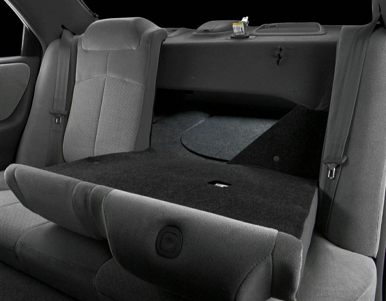 Fold-flat rear seat with cargo space expansion and seat belt details