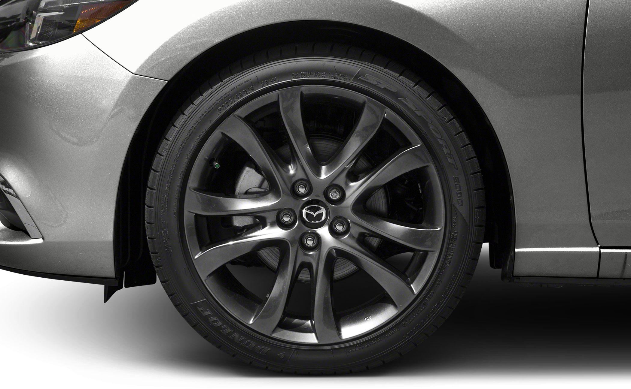 Alloy wheel with Mazda emblem and Dunlop tire on front fender