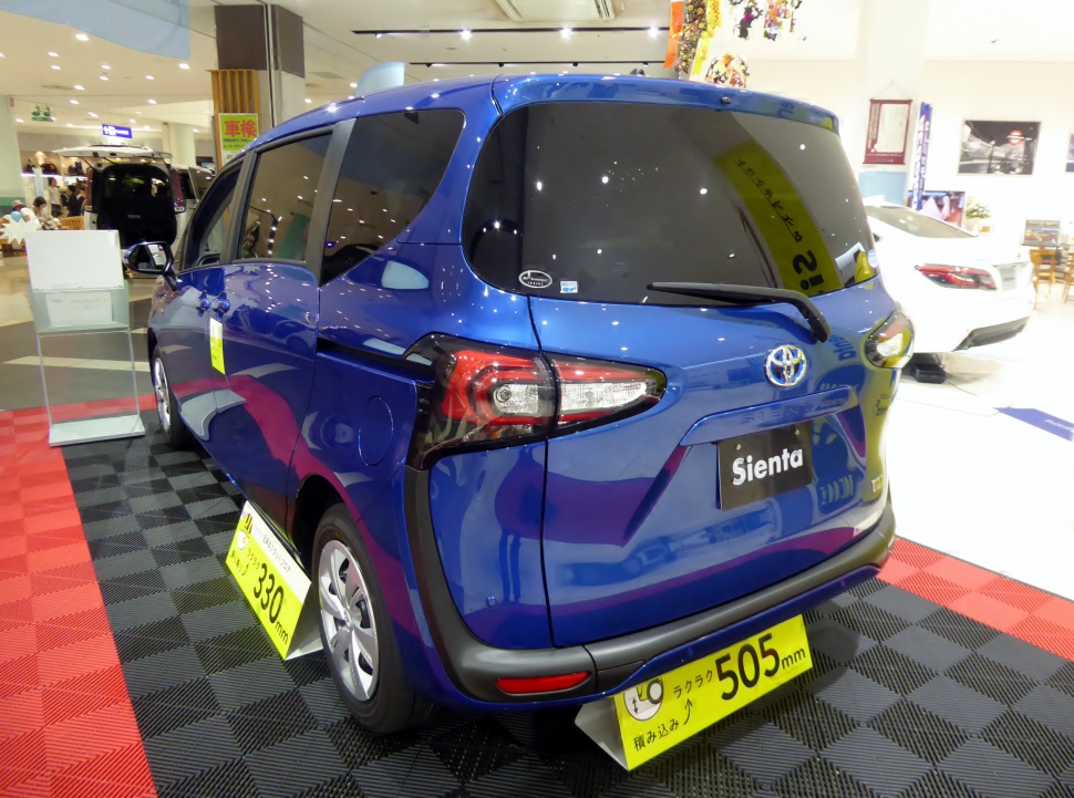 Rear view of compact MPV featuring tail lights and tinted rear window.
