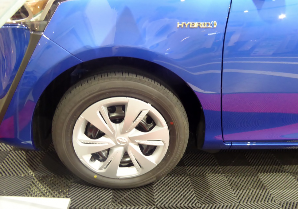 Close-up of wheel rim and hybrid badge on compact vehicle
