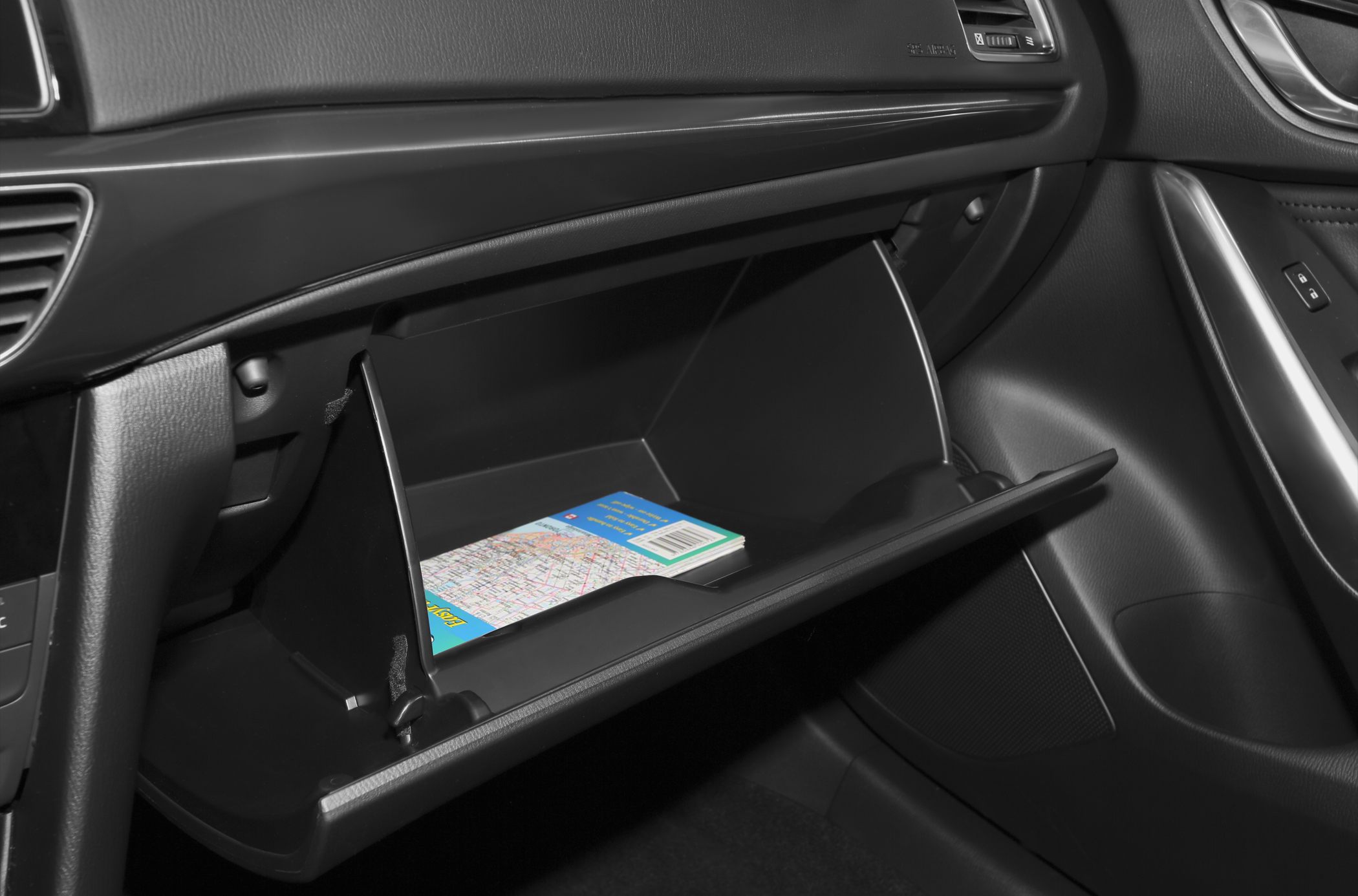 Open glove compartment with map inside, car interior storage