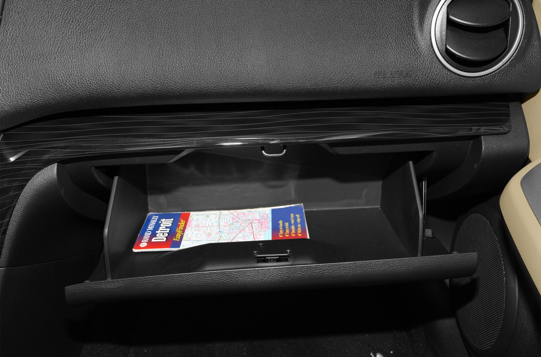 Open glove compartment with a map inside in car interior