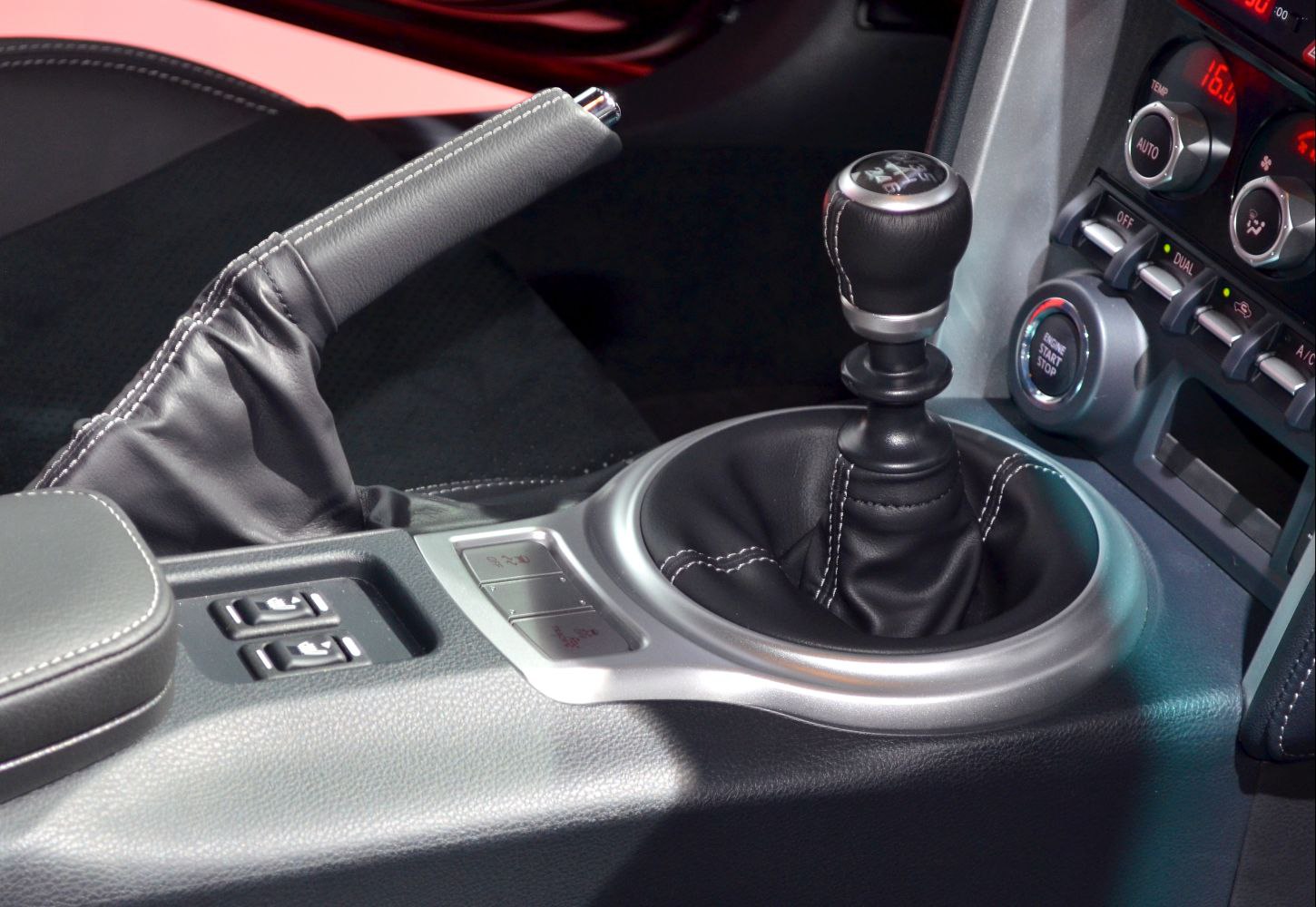 Manual gearshift and handbrake with leather stitching in car interior