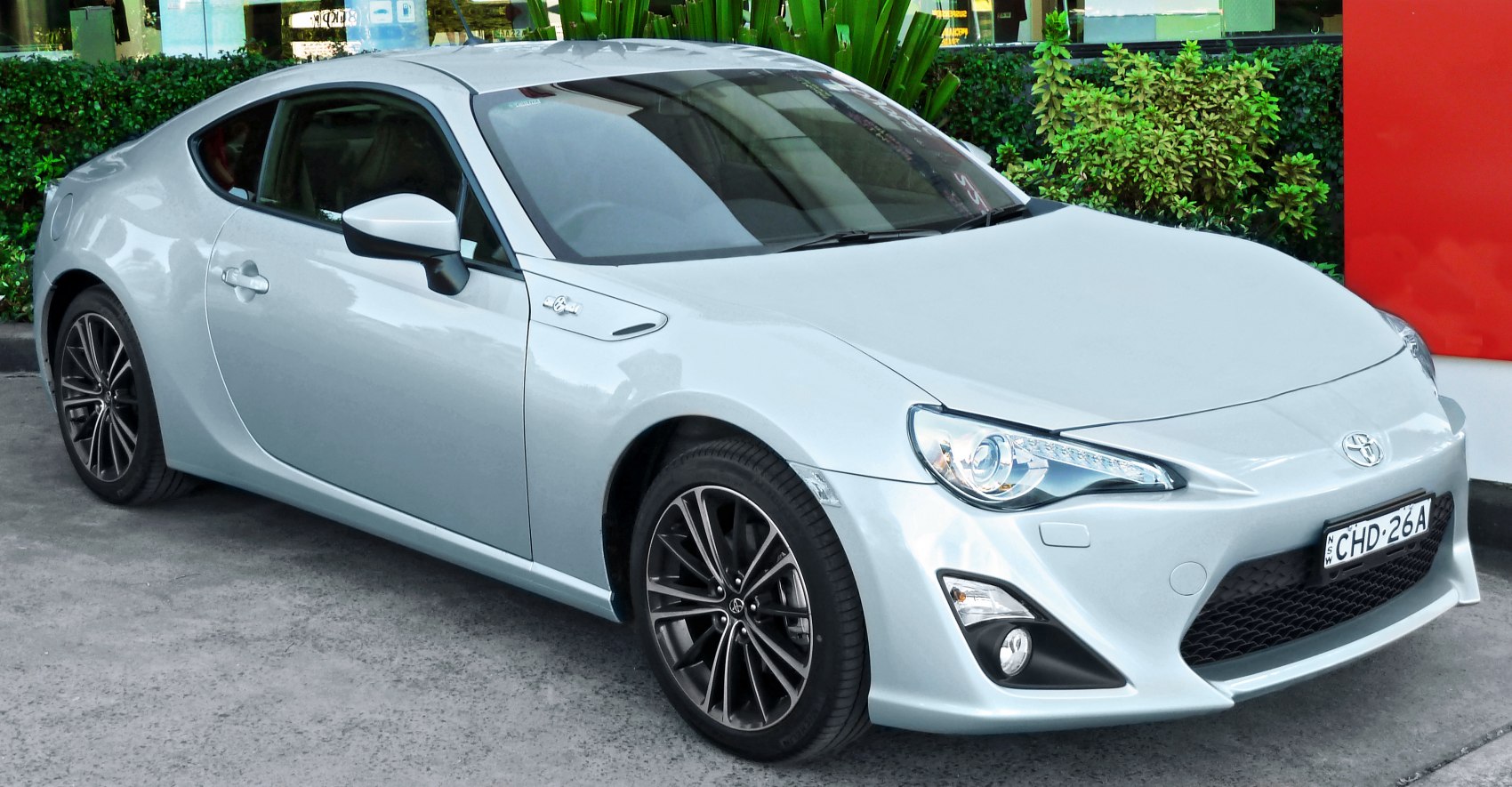 Sleek white sports coupe front-side view with alloy wheels