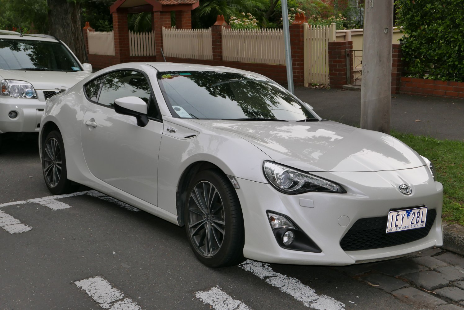 White sports coupe front side view with alloy wheels