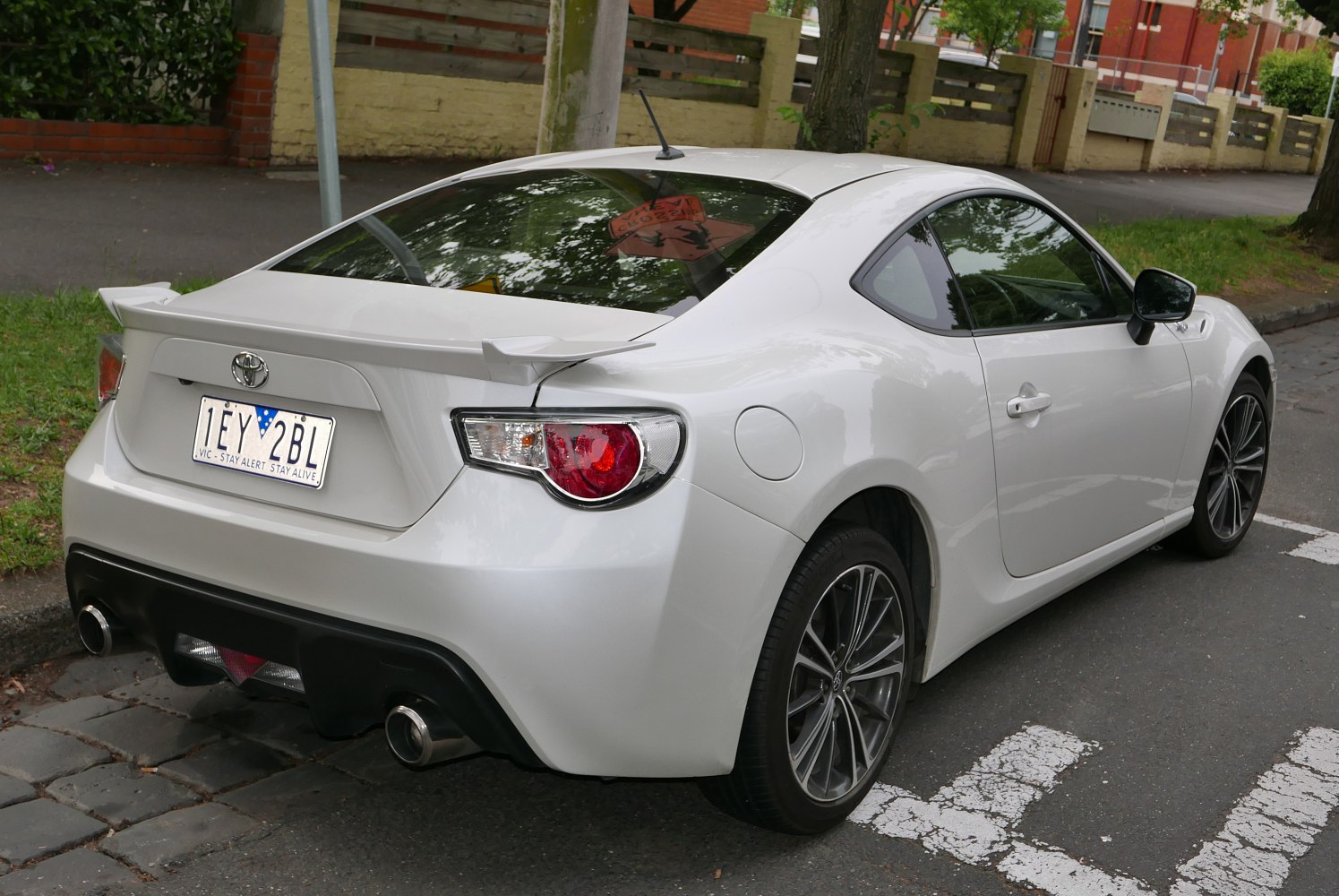 Rear view of a sports coupe with spoiler and dual exhaust