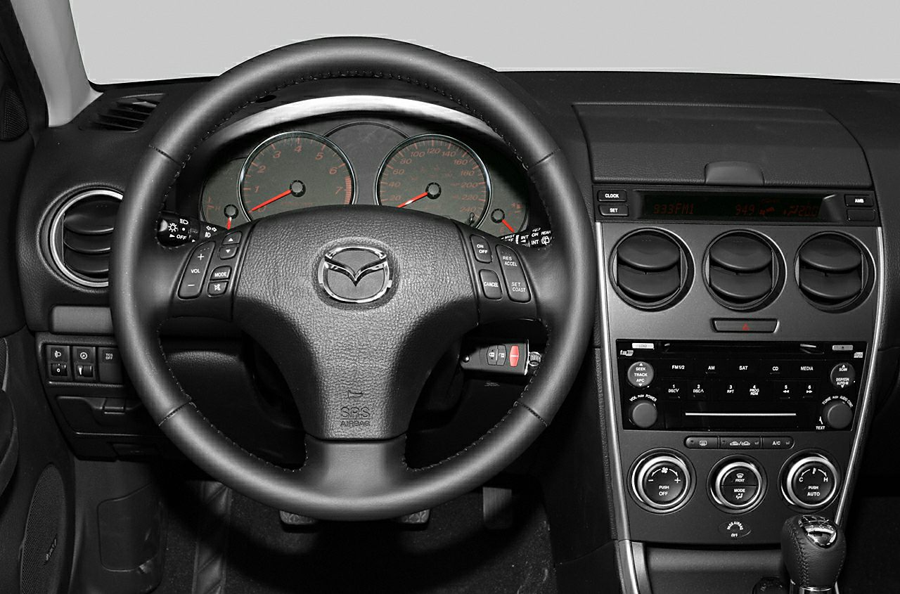 Steering wheel with controls and dashboard with air vents and radio