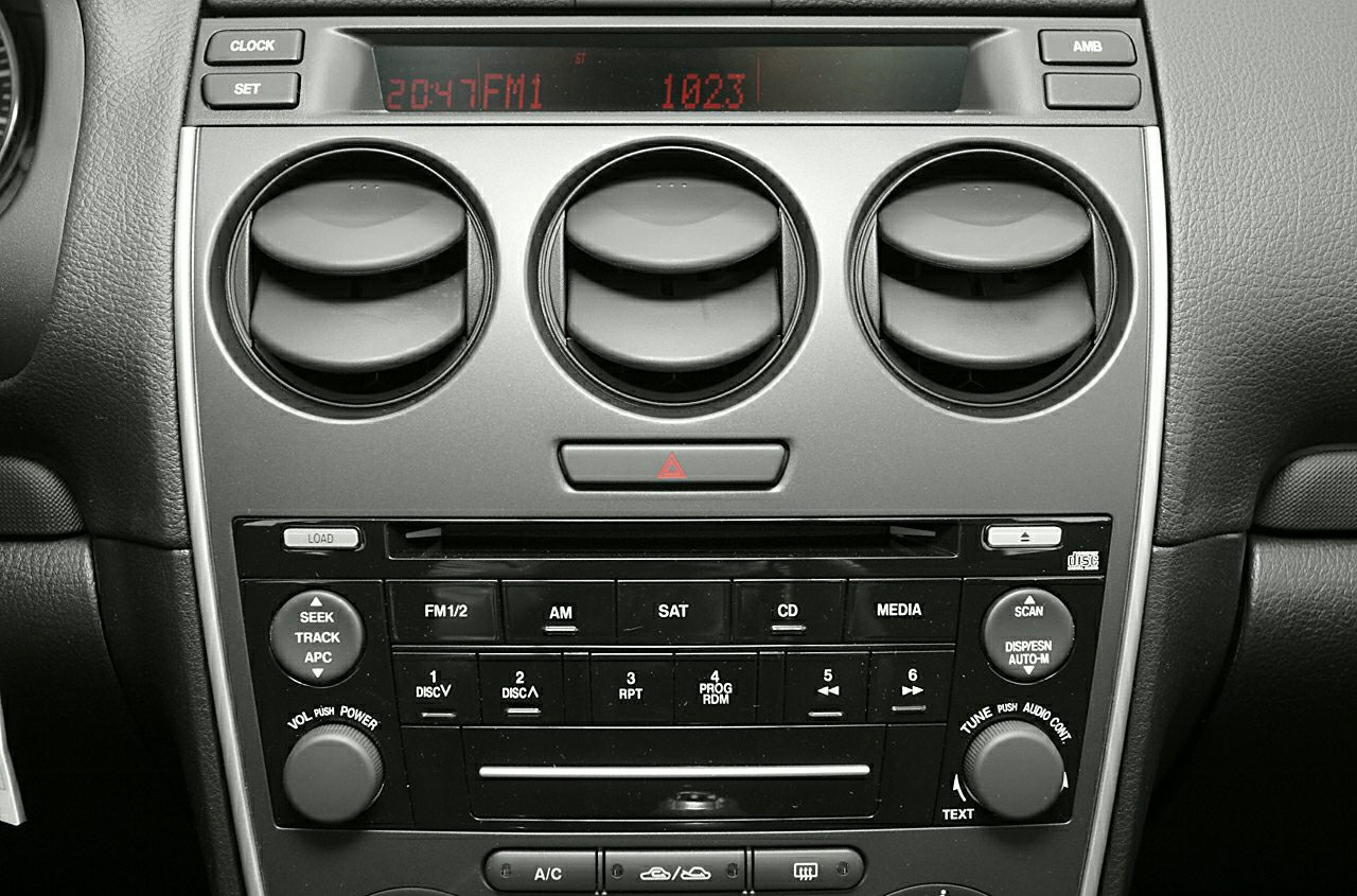 Audio system panel with control buttons and three circular air vents