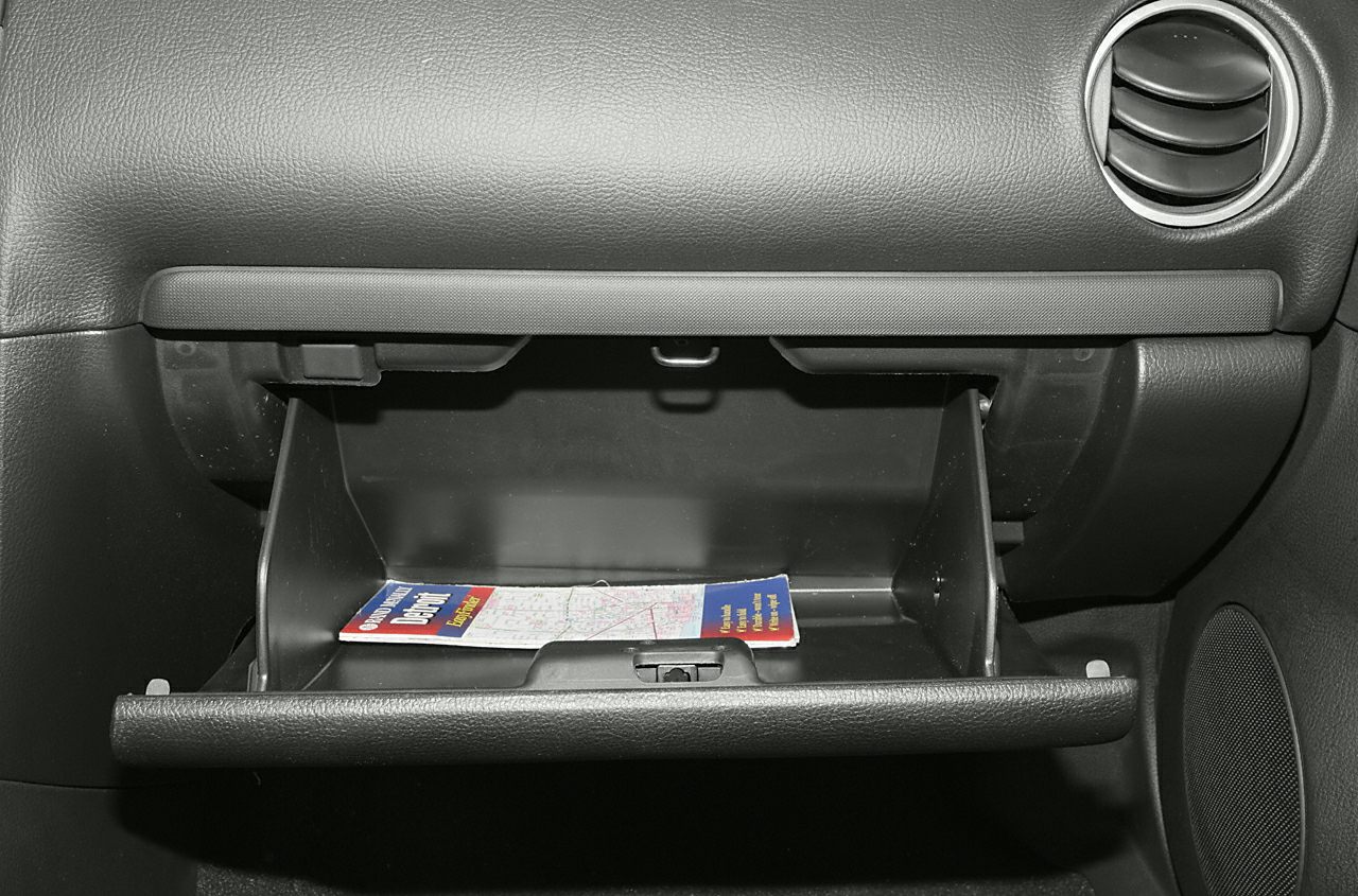 Open glove compartment with map inside and dashboard vent