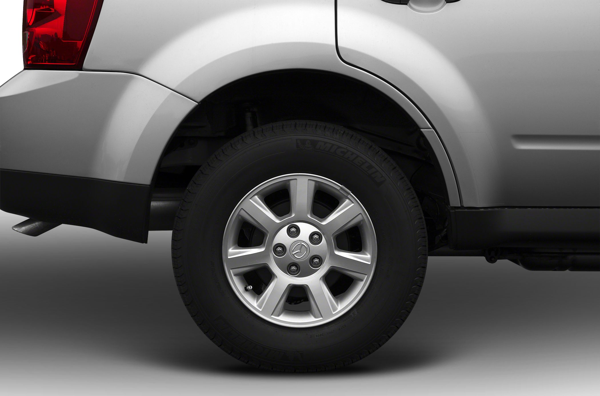 Close-up of rear wheel and tire on silver SUV with alloy rim