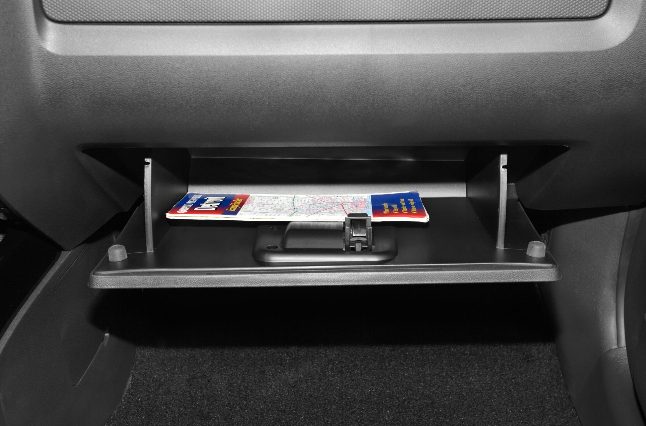 Open SUV glove box with folded road map inside