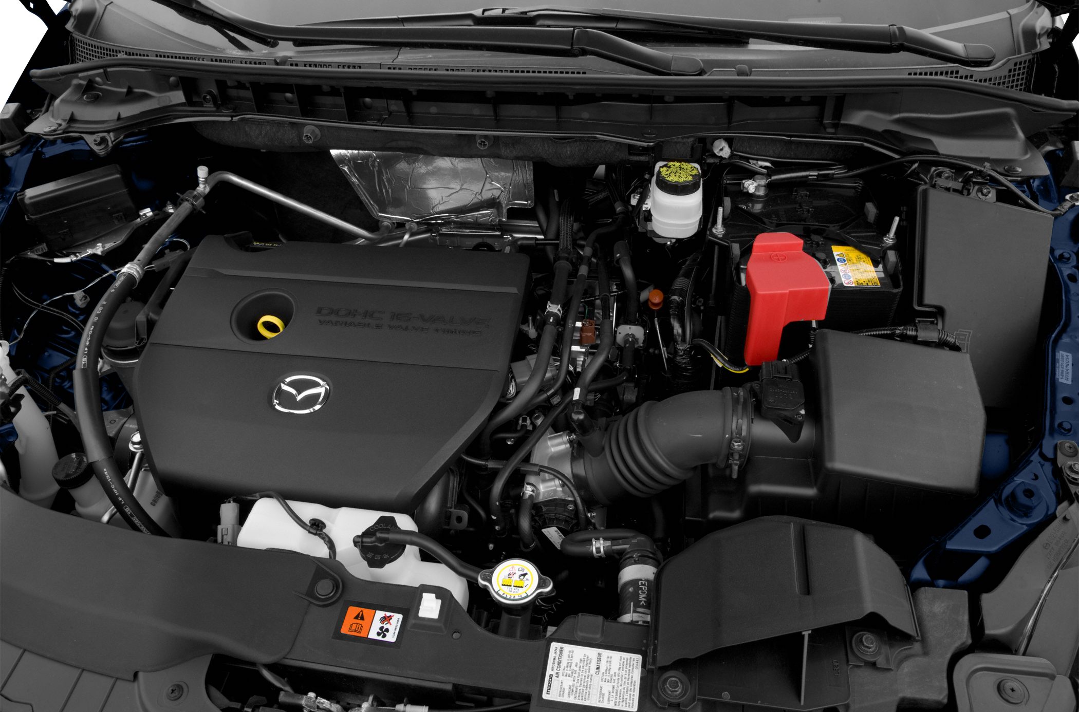 Engine compartment with covered engine, battery, hoses, and fluid reservoirs.