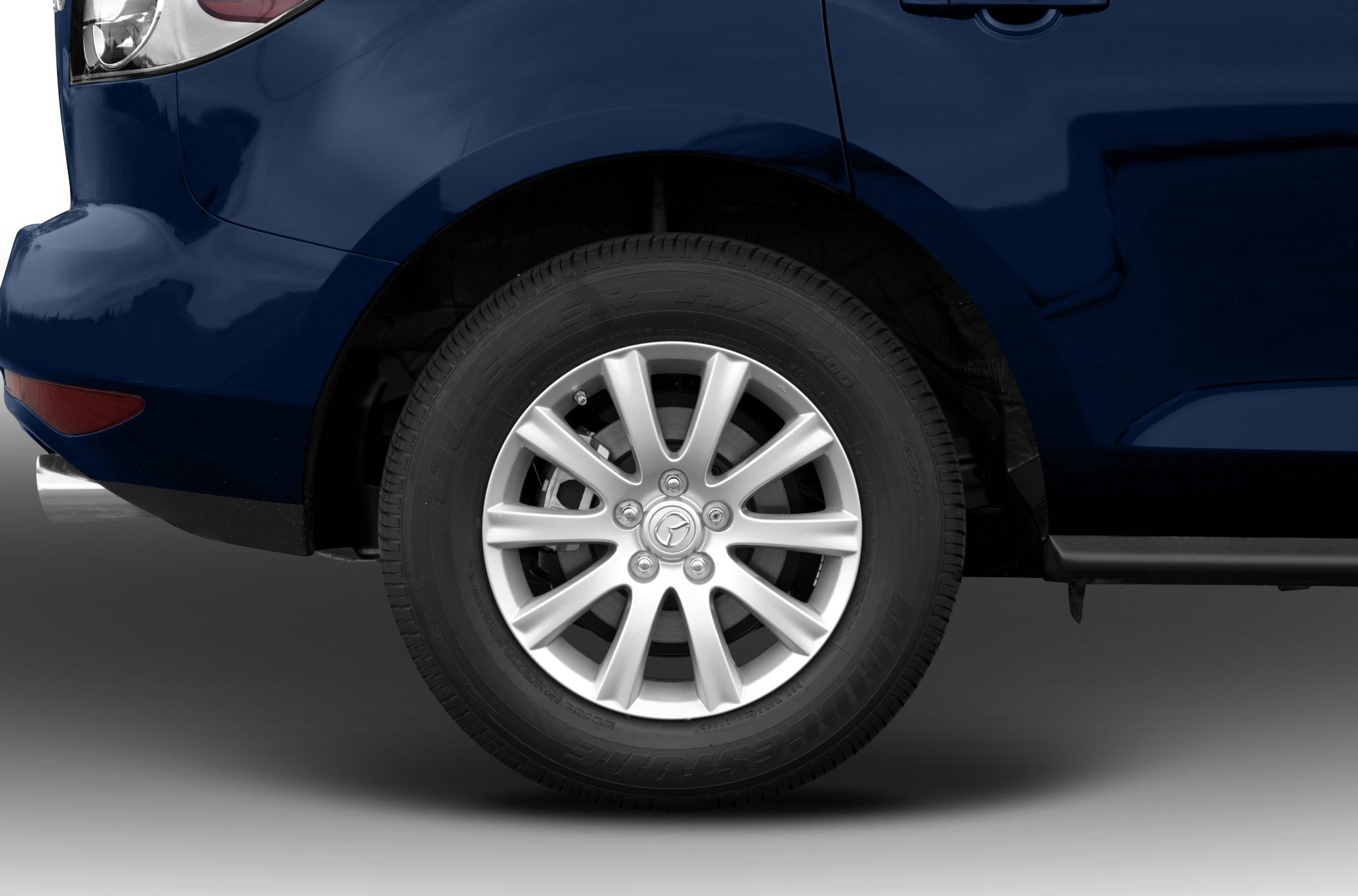 Close-up of alloy wheel and Bridgestone tire on blue vehicle