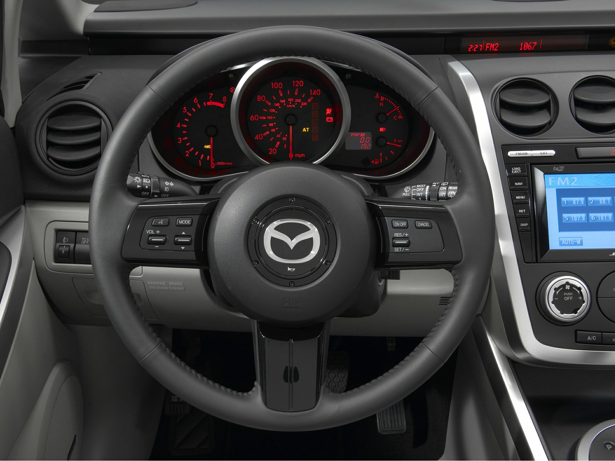 Steering wheel, dashboard, and instrument panel with controls and displays.