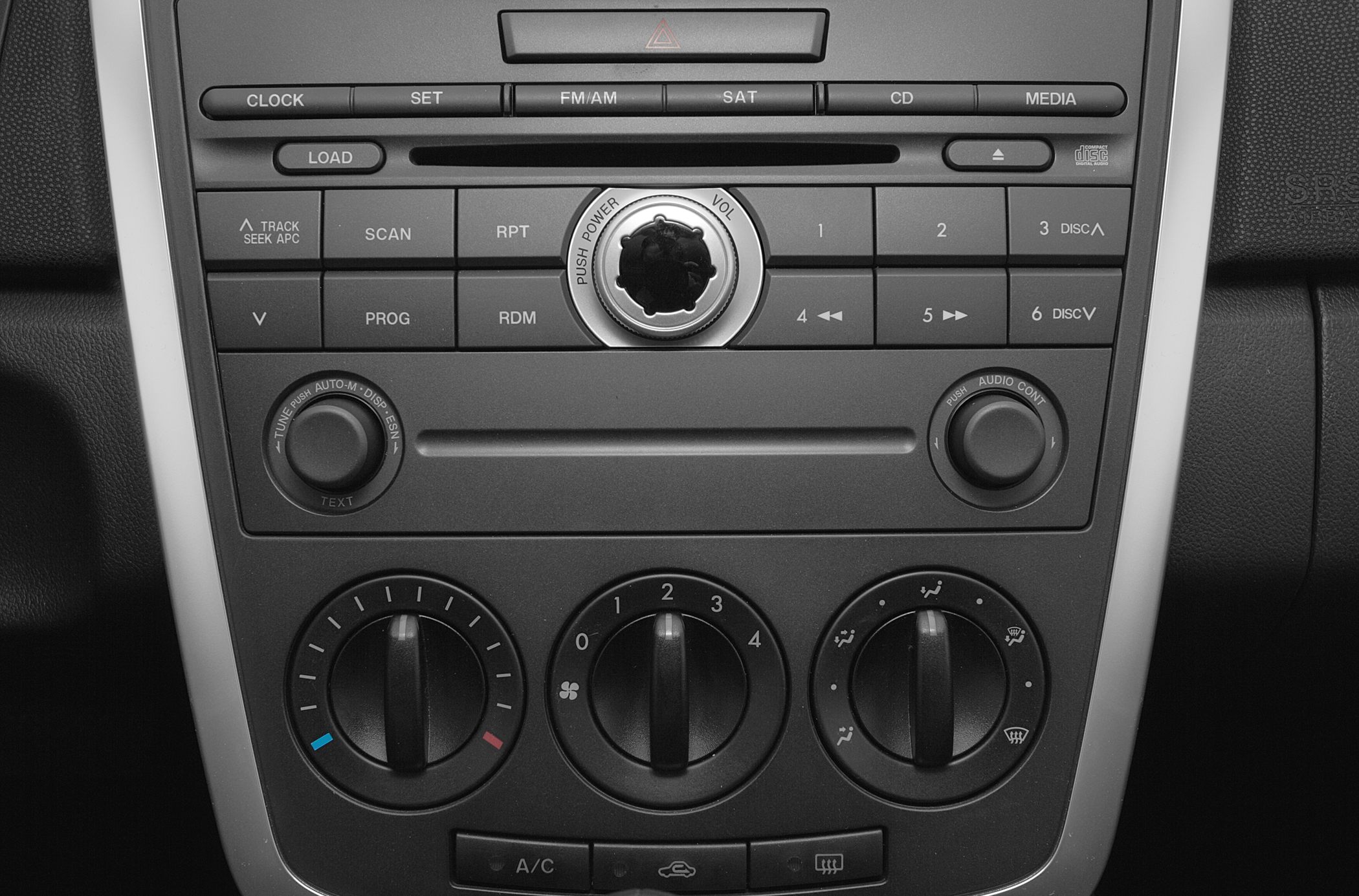 Close-up of car audio system and manual climate controls with knobs and buttons