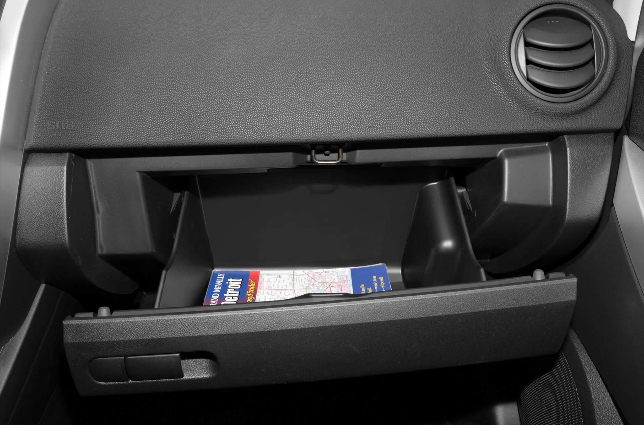 Open glove compartment with map inside in car interior