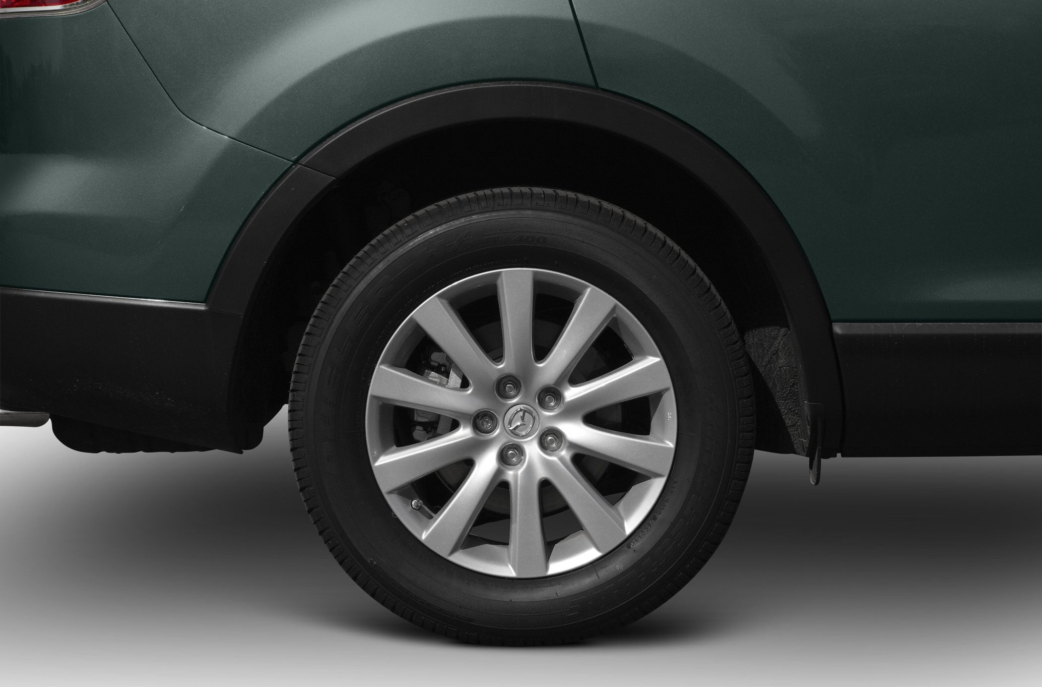Close-up of a silver alloy wheel and tire on a SUV's rear wheel arch